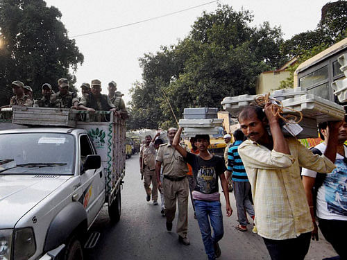 Workers carry EVM ahead of polling of the third phase of Bihar Assembly Polls in Patna, Bihar on Tuesday. PTI Photo