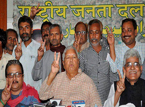 RJD Chief Lalu Prasad Yadav with party leaders showing victory symbol during a press conference after the last phase of Bihar elections, in Patna on Thursday. PTI Photo