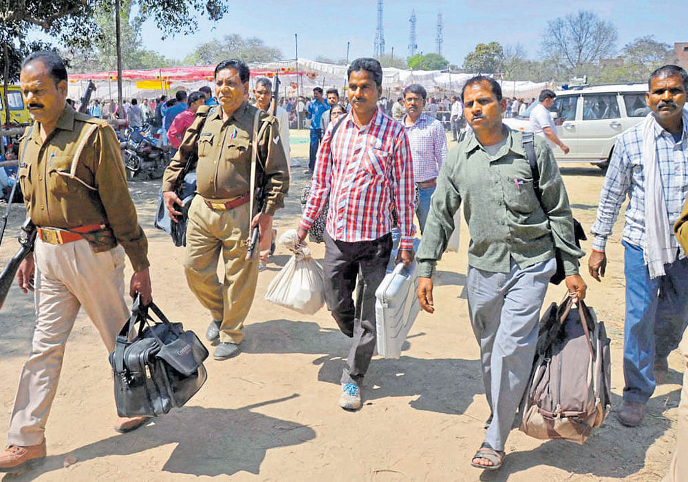 getting poll ready: Polling officers leave for election duty from an EVM distribution centre, in Mirzapur on Tuesday. PTI