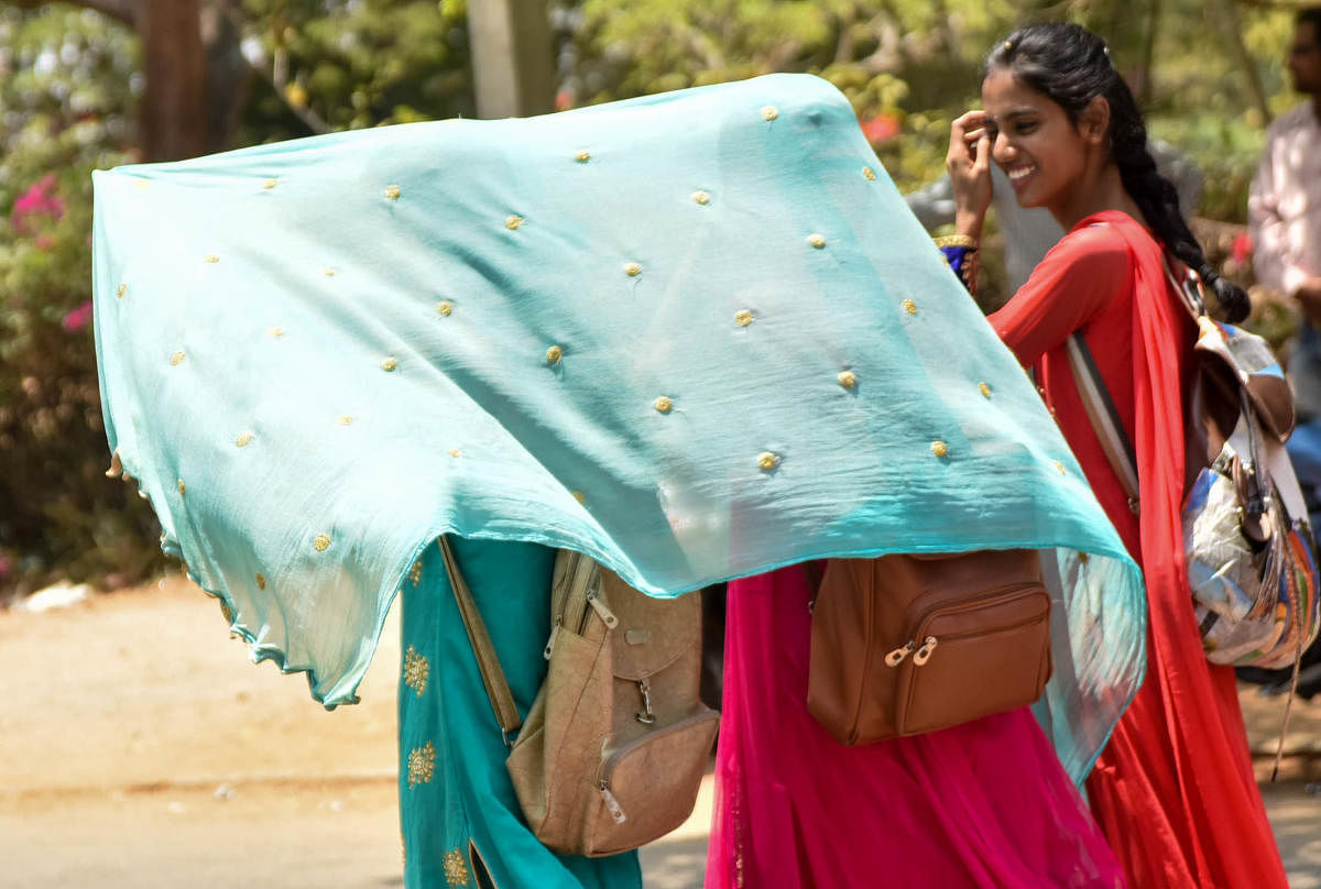 Women use dupatta to protect themselves from sun in Mysuru. DH file photo