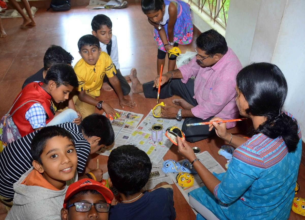 Artist Nageshwar trains students in preparing 'Cheriyal' masks at the Crafts Mela in Madikeri.