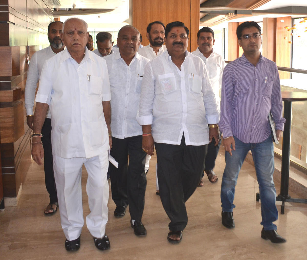 BJP state president B S Yeddyurappa comes out after a meeting with the Katti brothers in Belagavi on Monday. Umesh Katti, Chikkodi candidate Annasaheb Jolle and others are seen. dh photo