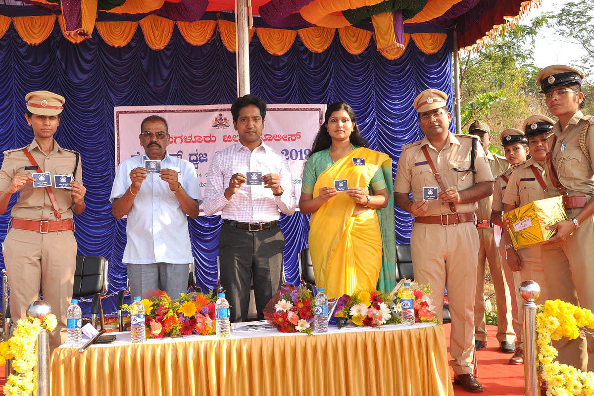 Deputy Commissioner Dr Bagadi Gautham releases police flag stickers during the Police Flag Day programme in Chikkamagaluru on Tuesday.