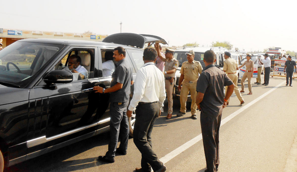 Officials on poll duty intercept Chief Minister H D Kumaraswamy's car, on National Highway 75, at Hirisave, Hassan district, on Wednesday.