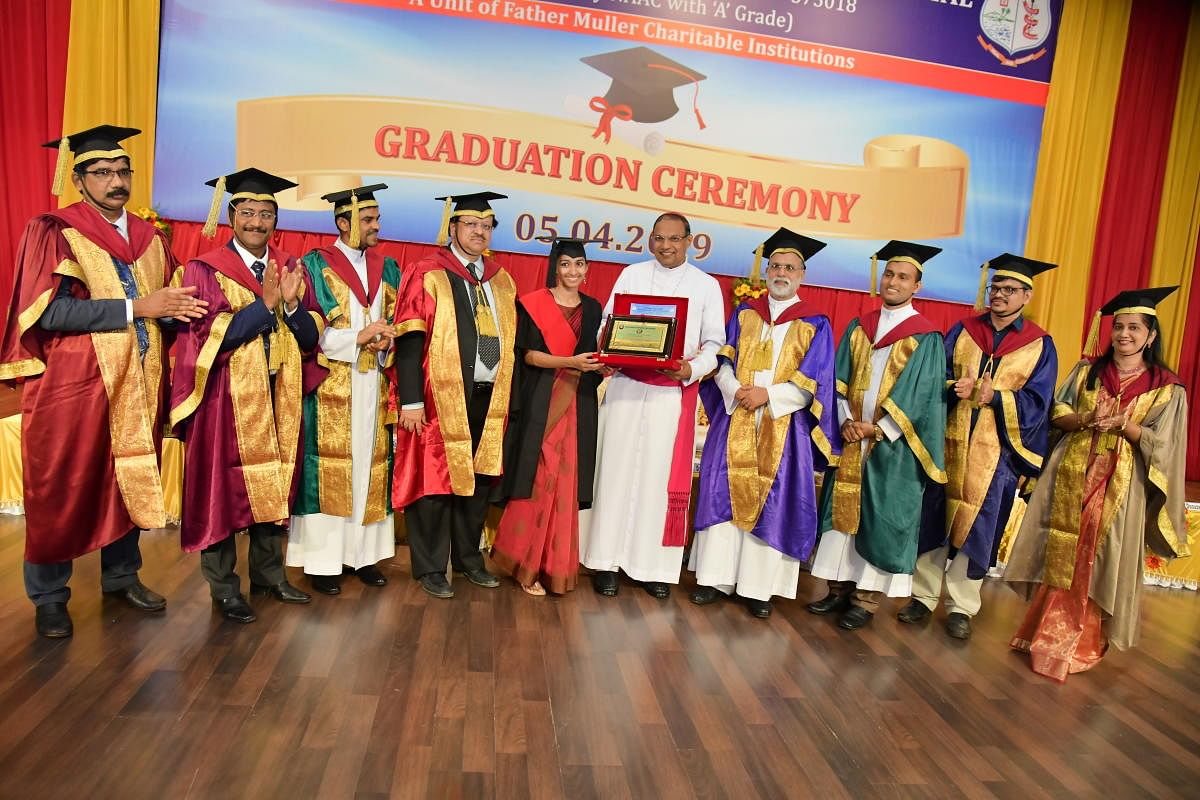 Mangaluru Bishop and Father Muller Charitable Institutions (FMCI) President Rev Dr Peter Paul Saldanha presents the Presidents Gold medal to outgoing meritorious student Dr Aleena Thomas at Father Muller Homeopathic Medical College’s (FMHMC) 29th graduation ceremony organised at Father Muller Convention Centre in Mangaluru on Friday.