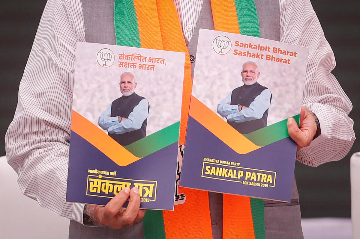 Prime Minister Narendra Modi displays copies of Bharatiya Janata Party (BJP) election manifesto for the April/May general election in New Delhi, India, April 8, 2019. REUTERS