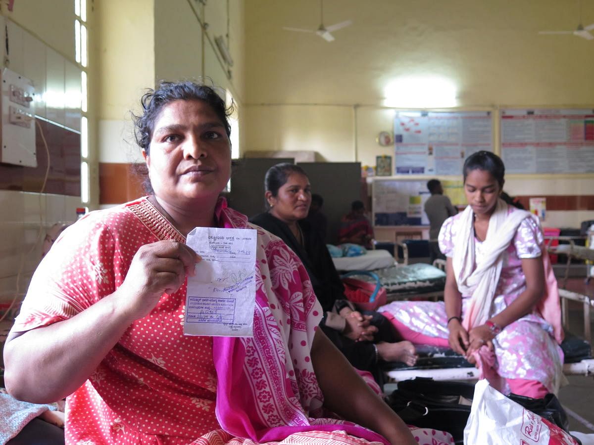 Shanshad, a 36-year-old coolie and a beedi seller, shows her hospital-approved coupon for a blood test, at Victoria Hospital in Bengaluru on April 7, 2019. Although the Arogya Karnataka scheme covered her hernia operation, she found that the government treated all other hospital charges as co-pay - in this case, half of all ancillary charges, including bed and testing charges had to be paid by the patient.