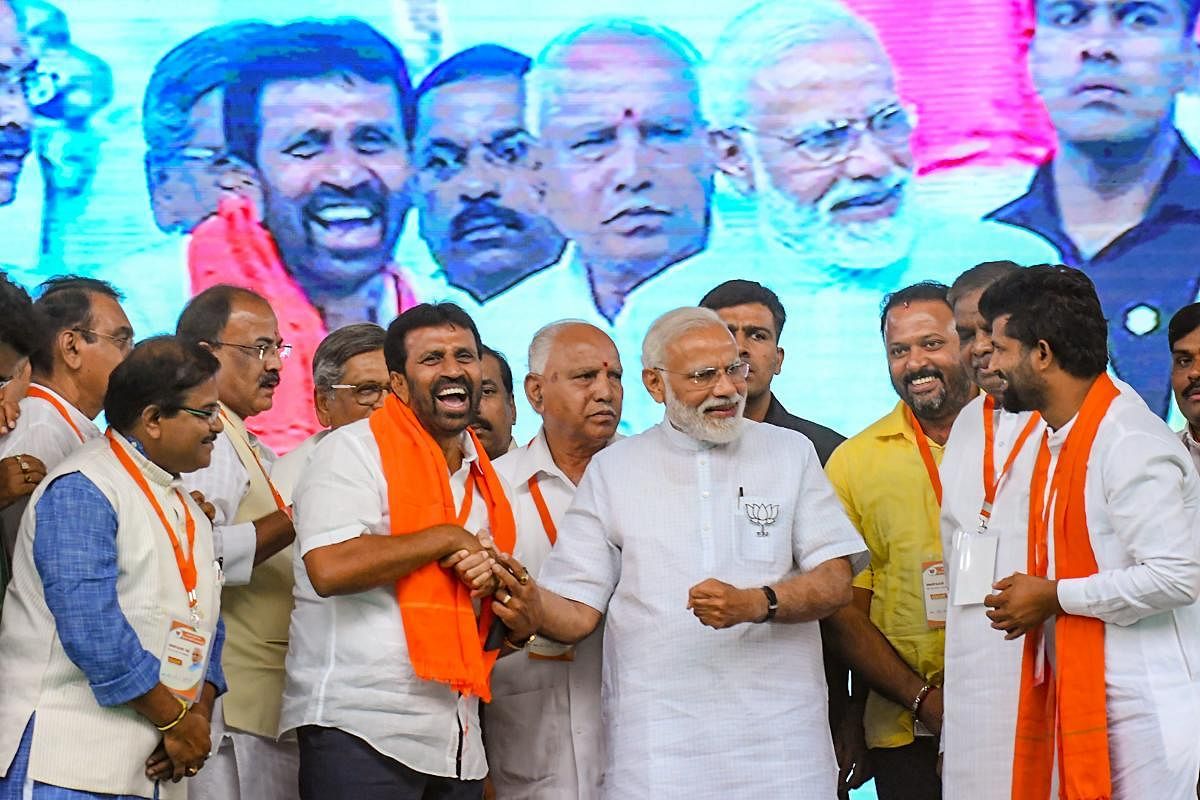 Prime Minister Narendra Modi banters with Chamaraja MLA L Nagendra and Mysuru-Kodagu MP Prathap Simha during the BJP's campaign rally in Mysuru on Tuesday. State BJP president B S Yeddyurappa and others look on. pti