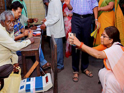 BJP candidate Rupa Ganguly clicks photo in her mobile inside a polling booth during 4th phase of assembly elections in Howrah on Monday. PTI Photo