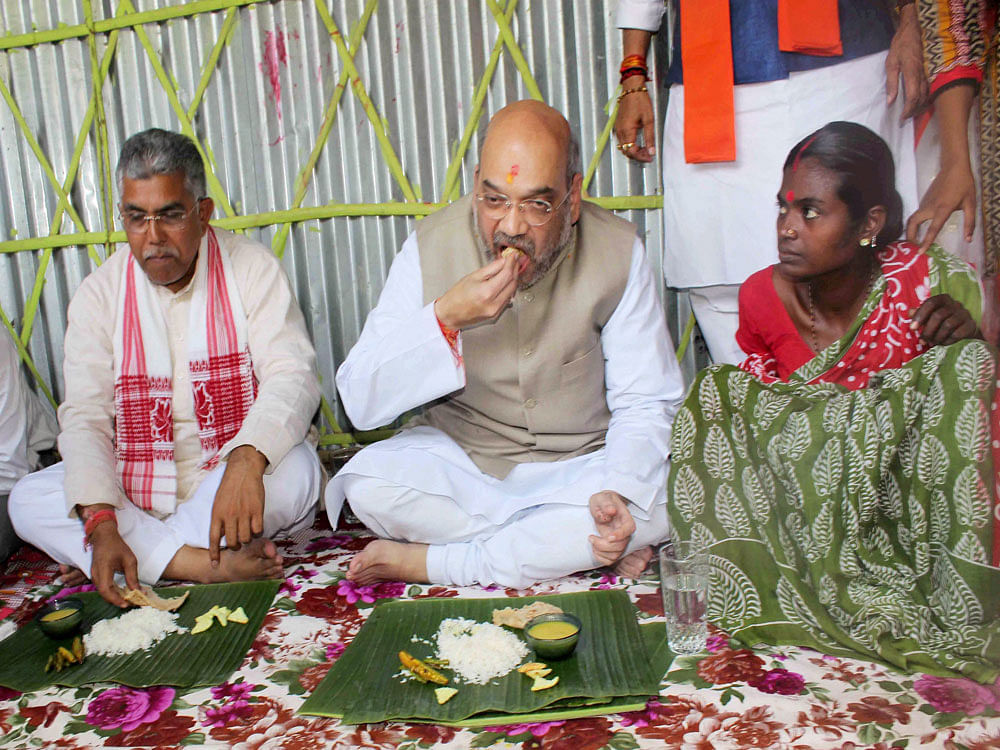 Amit Shah partaking of lunch during his visit to the family in his Naxalbari visit. Photo credit: PTI.