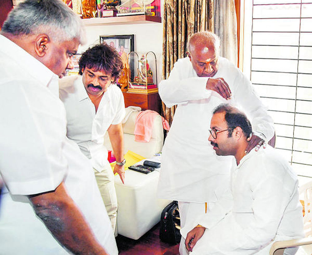 JD(S) supremo H D Deve Gowda blesses former minister Anand Asnotikar at the former's residence in Bengaluru on Monday. Asnotikar formally joined JD(S) on the occasion. Party leaders H D Revanna and Madhu Bangarappa are seen. DH Photo