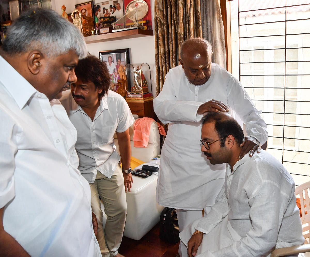 JD(S) supremo H D Deve Gowda blesses former minister Anand Asnotikar at the former's residence in Bengaluru on Monday. Asnotikar formally joined JD(S) on the occasion. Party leaders H D Revanna and Madhu Bangarappa are seen. DH Photo