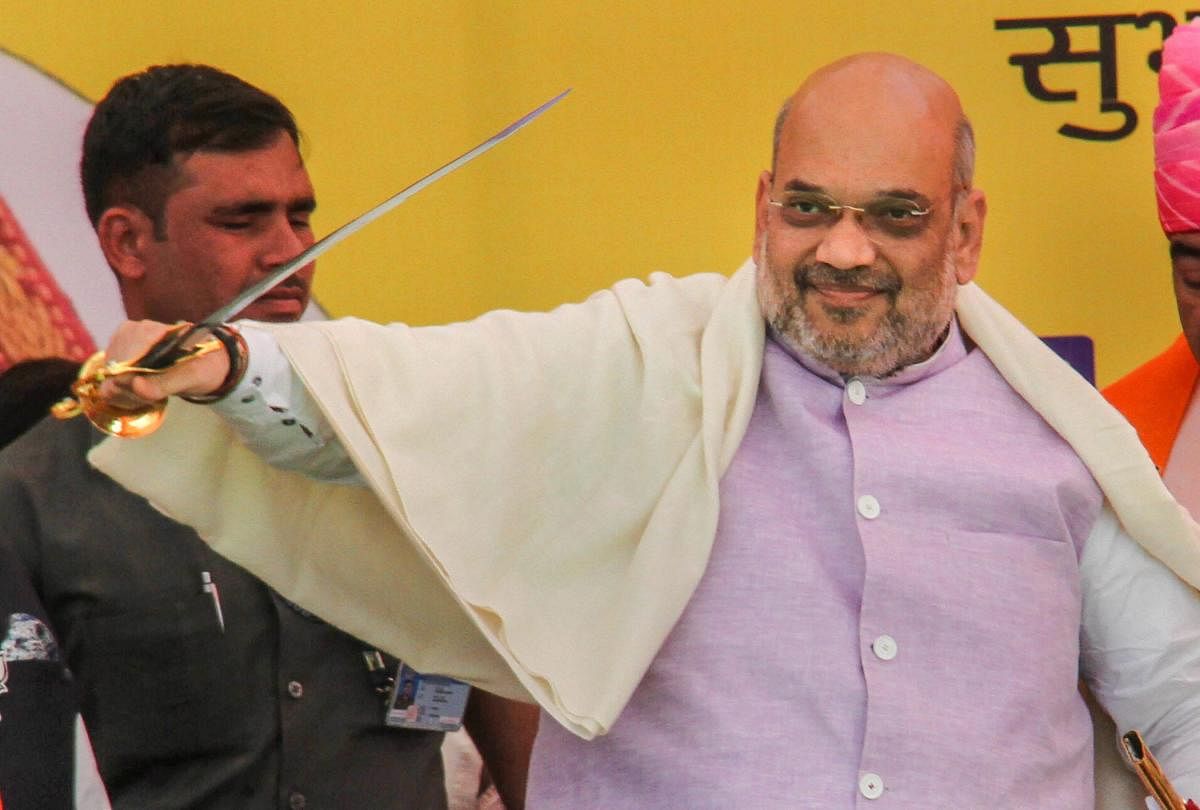 Bharatiya Janata Party National President Amit Shah holds a sword presented to him during an election rally, ahead of the Lok Sabha polls, in Udhampur about 68kms from Jammu, Wednesday, April 3, 2019. (PTI Photo)