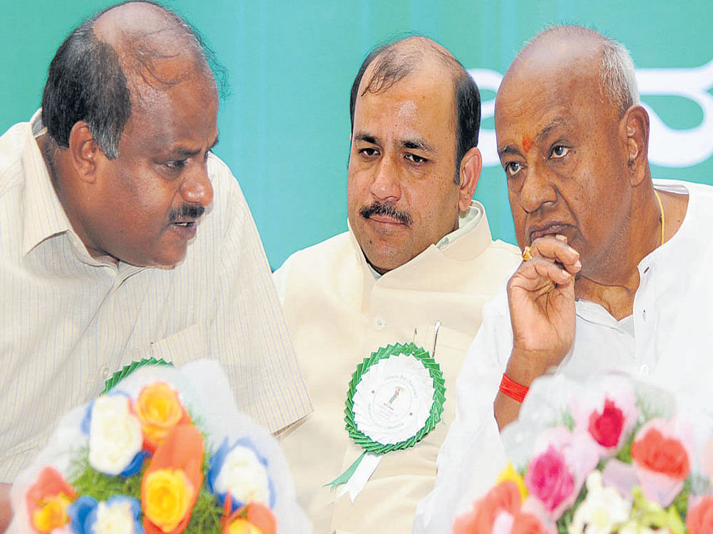 In picture: JDS supremo and former PM H D Deve Gowda (R) in conversation with his son H D Kumaraswamy (L). DH Photo.  
