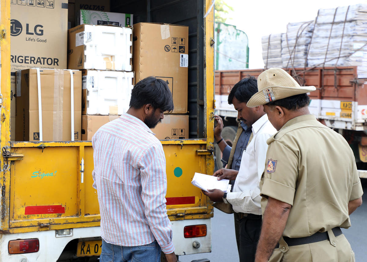 Personnel of a static surveillance team check the vehicle at election checkpost on Magadi Chord Road in Bengaluru on Thursday. DH Photo/Sudheesha K G