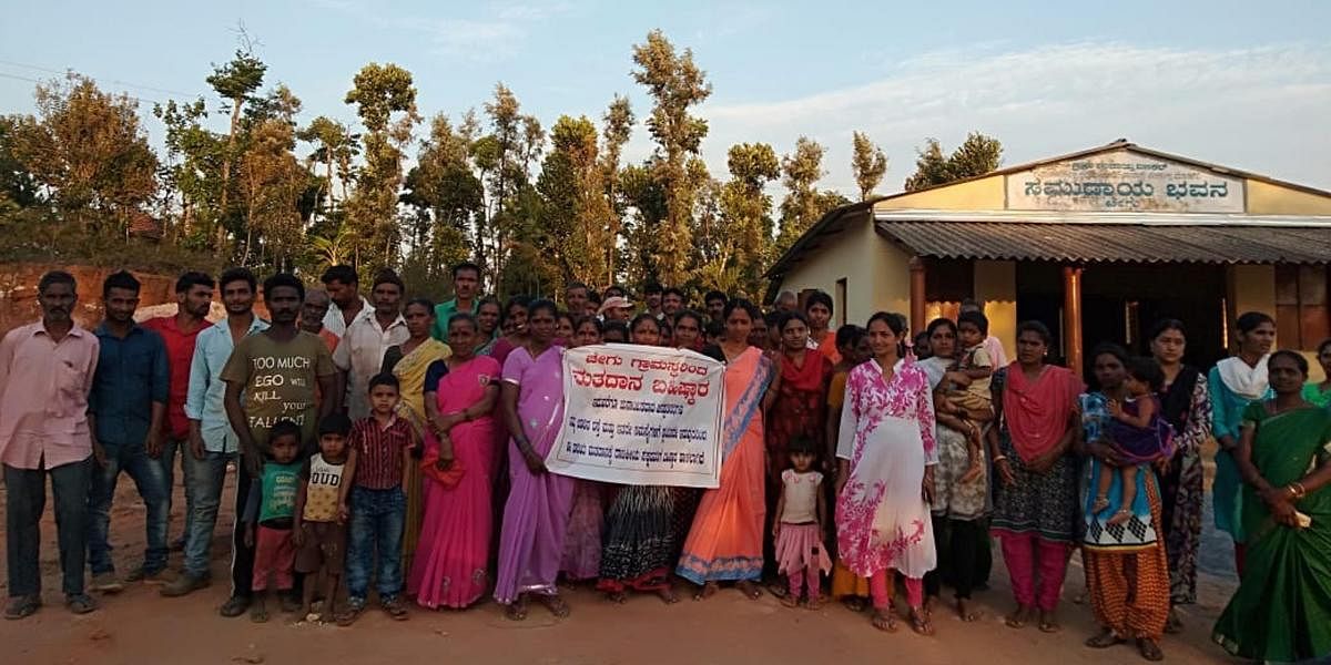 Residents in Chegu village of Mudigere taluk hold a banner declaring their decision to boycott the Lok Sabha elections.