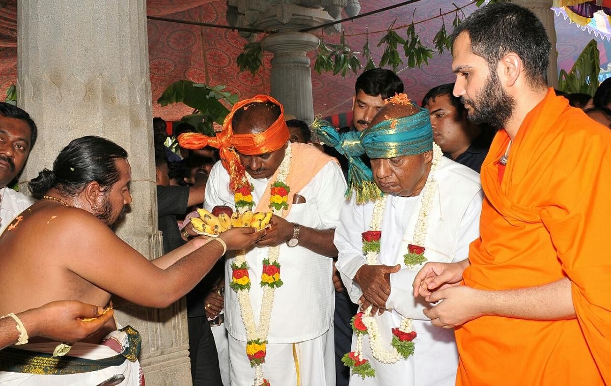 JD(S) supremo H D Deve Gowda and Chief Minister H D Kumaraswamy at Pattanayakanahalli Mutt in Sira taluk, Tumakuru district, on Monday. Nanjavadhootha Swami looks on. DH PHOTO