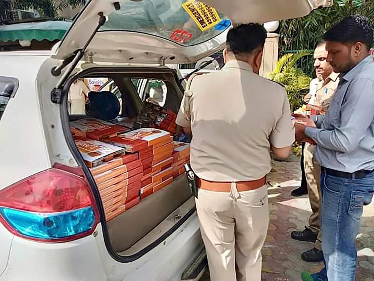 Police seize saffron coloured food packets from ‘Namo Foods’ which were being distributed outside a polling booth during the first phase of Lok Sabha polls in Gautam Buddh Nagar on Thursday. PTI photo
