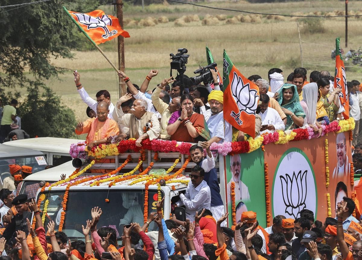 Union minister and BJP candidate Smriti Irani, accompanied by Uttar Pradesh Chief Minister Yogi Adityanath and other leaders, waves at the supporters during a roadshow before filing her nomination papers for Amethi Lok Sabha seat, in Amethi on April 11, 2