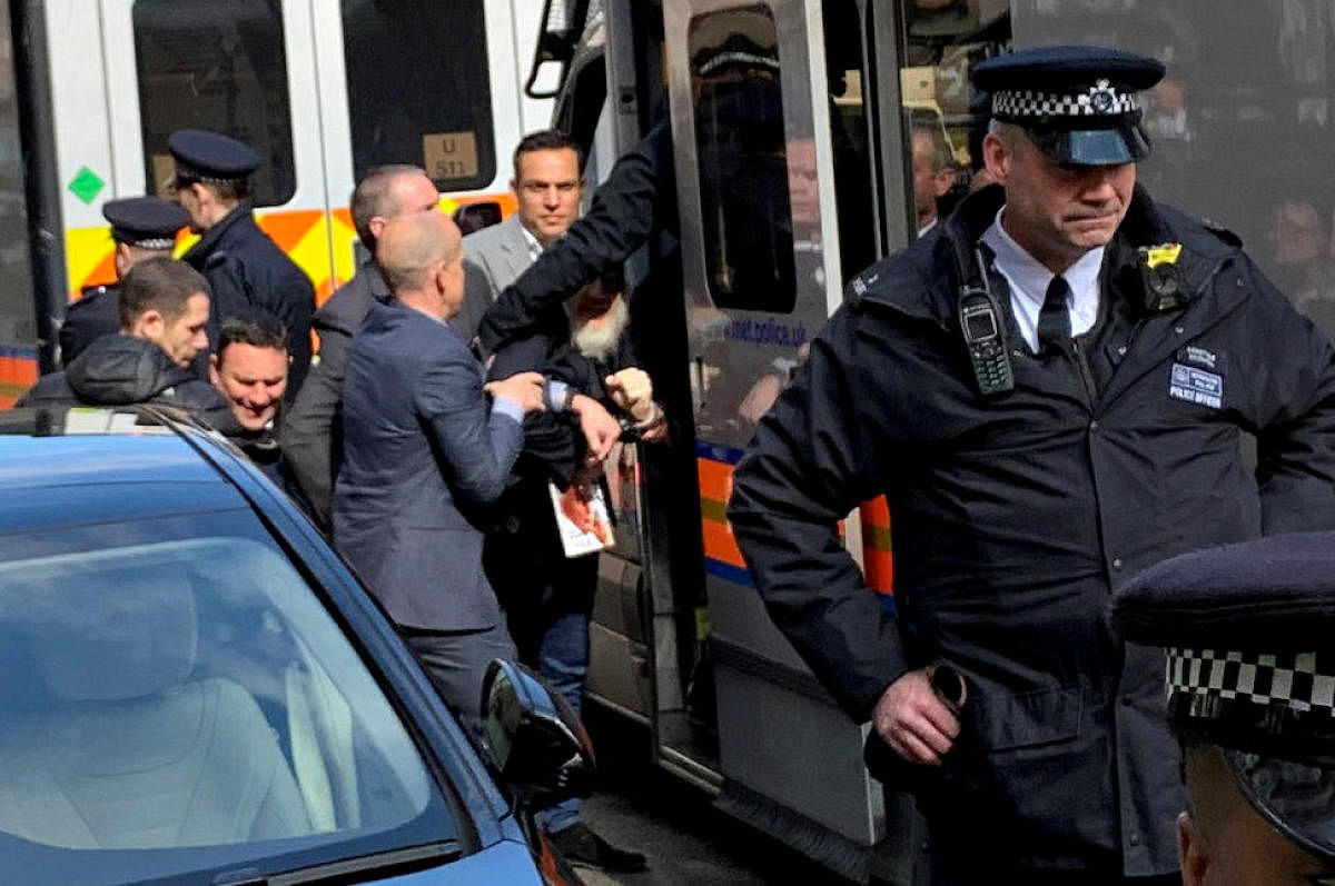 WikiLeaks founder Julian Assange is handled by Metropolitan Police officers during his arrest and taken into custody following the Ecuadorian government's termination of asylum, in London, Britain April 11, 2019 in this image obtained from social media. R