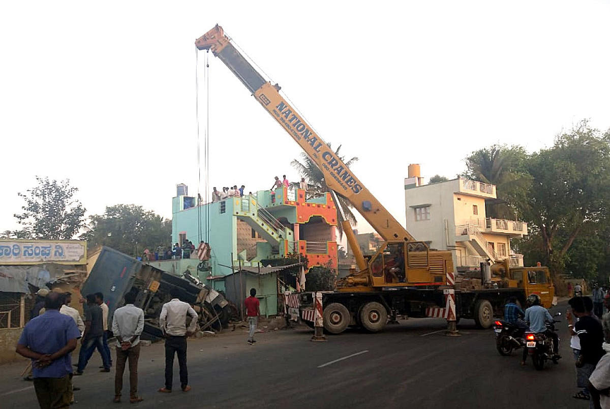 JCB lifting the Sand loaded tripper which kills two persons were their sleep after the truck abandoned building on National hghway on the wee hours on Saturday in Bodanahosalli village near Hosakote.