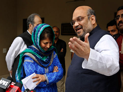 India's ruling Bharatiya Janata Party (BJP) president Amit Shah, right, gestures to the media after a meeting with Kashmir's regional Peoples' Democratic Party (PDP) leader Mehbooba Mufti, left in blue, in New Delhi, India, Tuesday, Feb. 24, 2015. The BJP and the PDP Tuesday finalized an agreement to form a coalition government in Kashmir, the first time the Hindu nationalist party will share a leadership position in the predominantly Muslim region. AP Photo