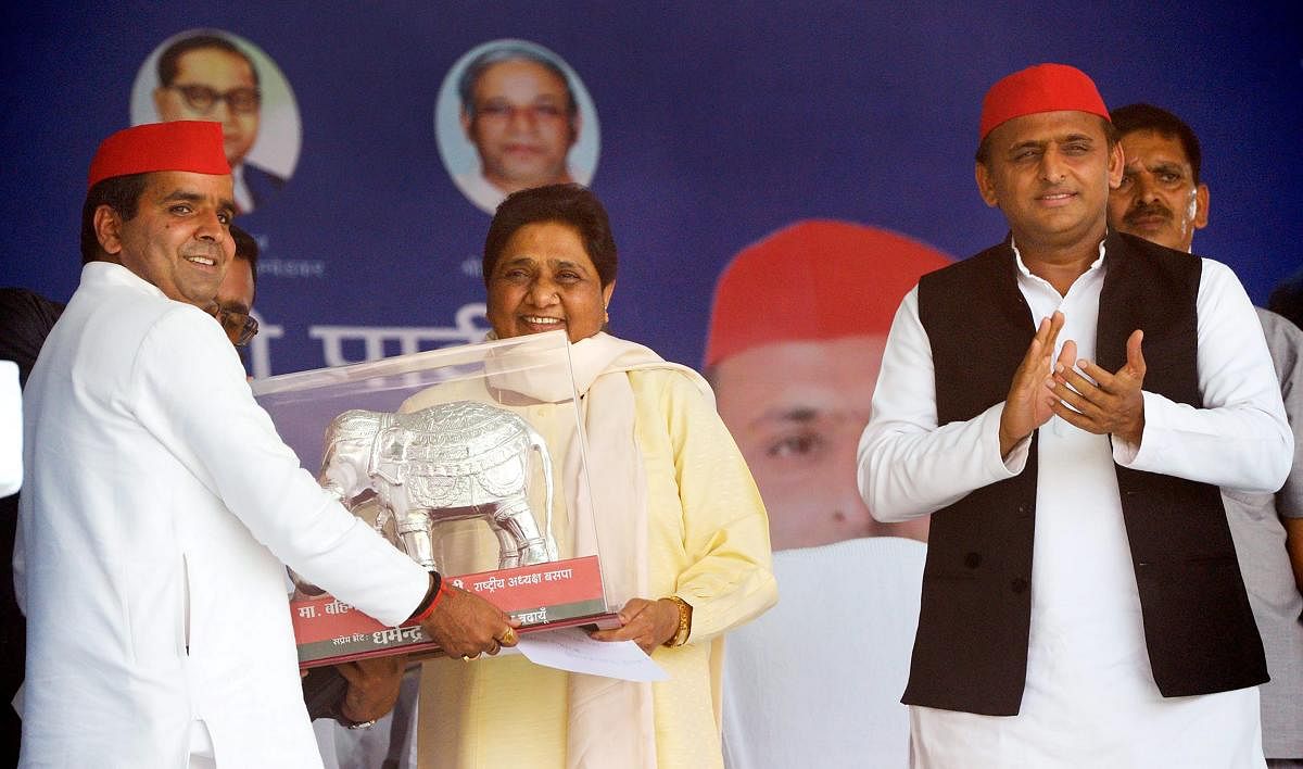 Bahujan Samaj Party supremo Mayawati being presented a memento by Samajwadi Party candidate Dharmendra Yadav as SP President Akhilesh Yadav claps, during their joint election campaign rally in Badaun, Saturday, April 13, 2019. (PTI Photo)