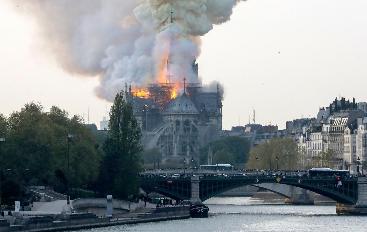 Smokes ascends as flames rise during a fire at the landmark Notre-Dame Cathedral in central Paris on April 15, 2019 afternoon, potentially involving renovation works being carried out at the site, the fire service said. AFP