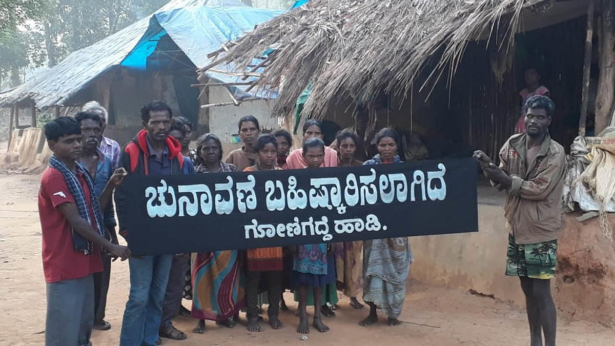 Residents of Gonigadde tribal hamlet display a banner, declaring the boycott of Lok Sabha elections.