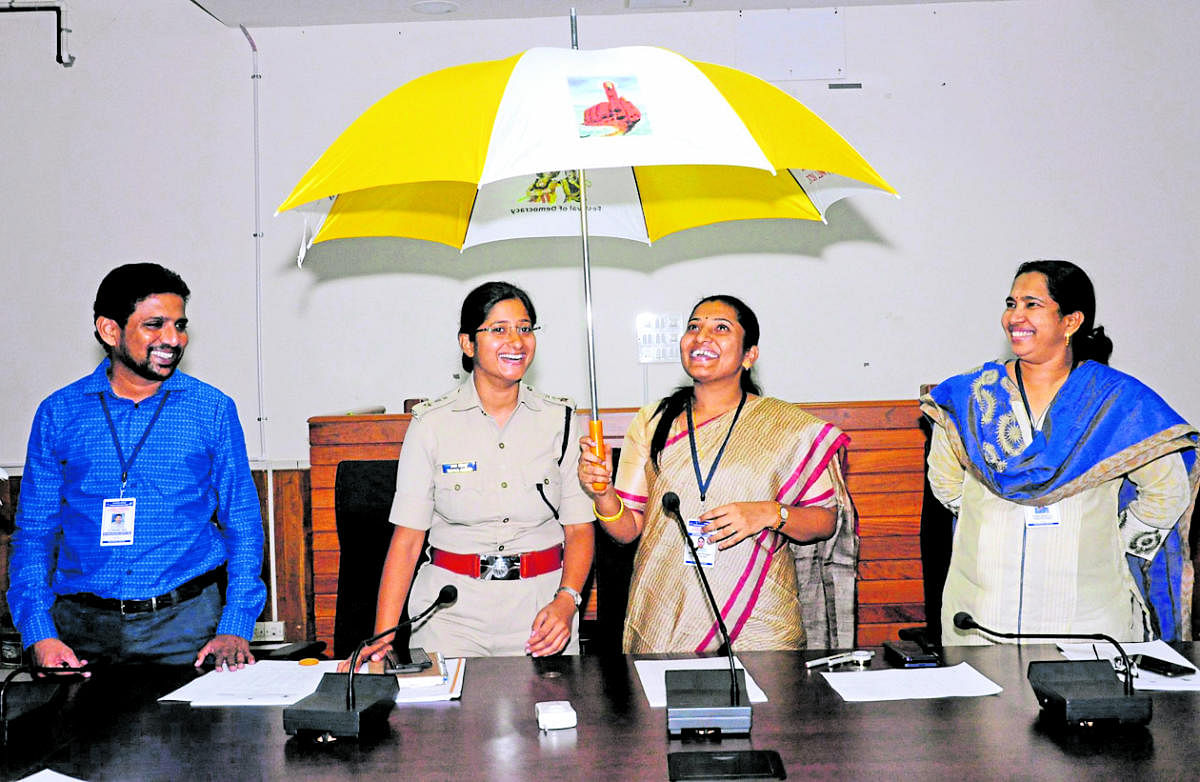Deputy Commissioner Hephsiba Rani Korlapati displays an umbrella, which has messages on the significance of voting, in Udupi on Tuesday. DH photo