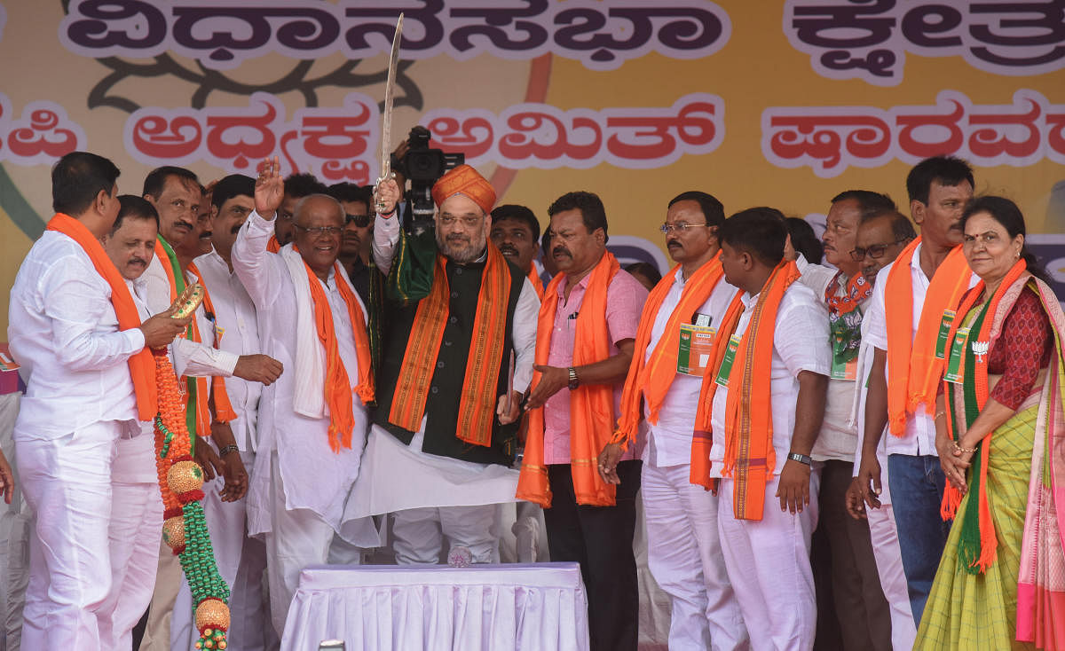 BJP national president Amit Shah is gifted a sword during the BJP rally in Honnali on Tuesday. Davangere Lok Sabha constituency candidate G M Siddeshwar is seen. DH Photo/Anup R Thippeswamy