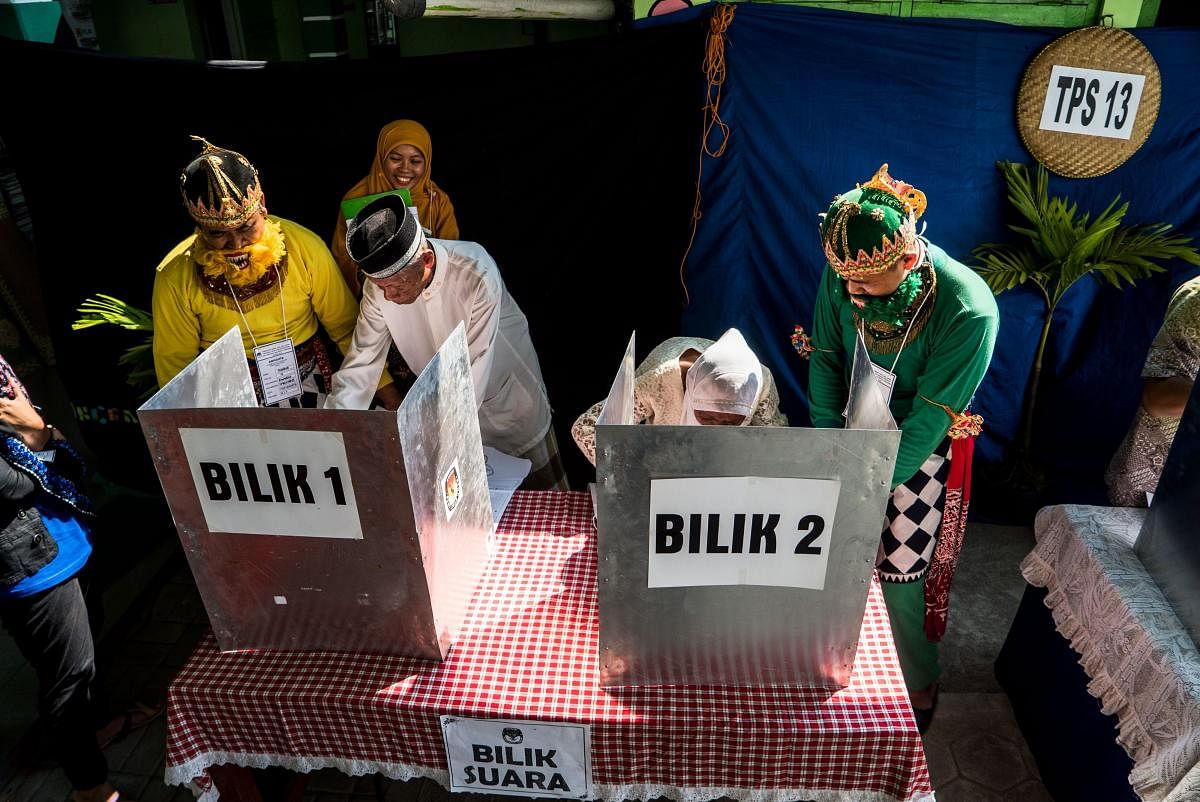 People cast their votes at a polling station during Indonesia's general election in Yogyakarta on April 17, 2019 (AFP)
