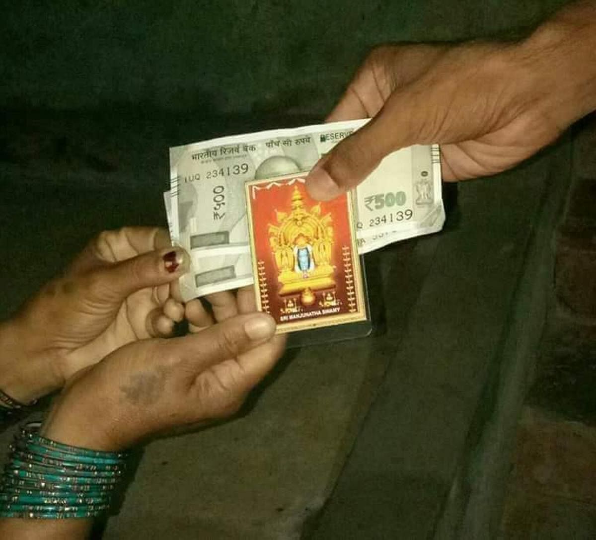 A photo of Dharmasthala Manjunatha Swamy being distributed along with money in Mandya.