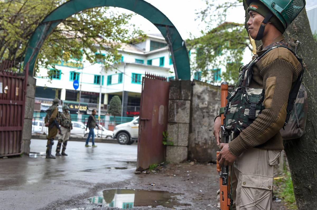 A security personnel stands guard outside an EVM distribution centre ahead of the second phase of Lok Sabha elections, in Srinagar on Wednesday. (PTI)
