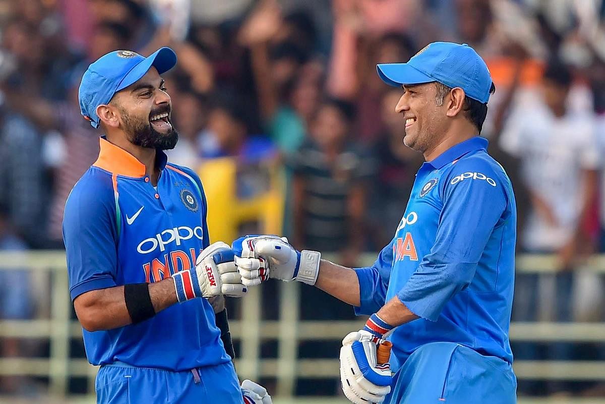 DYNAMIC DUO: Indian captain Virat Kohli share a light moment with MS Dhoni (right) on the field. PTI