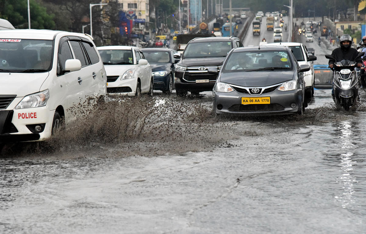 Vehicles move through heavy rain near Hebbal in Bengaluru on Wednesday. DH Photo by Janardhan B K