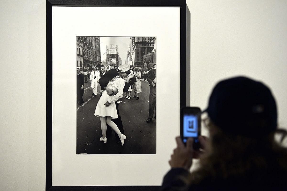 In this file photo taken on April 30, 2013 a visitor takes a snapshot of "VJ Day in Times Square, New York, NY, 1945" by Alfred Eisenstaedt during the "Life, I grandi fotografi", (The great photographers) exhibition at the auditorium in Rome. - The sailor