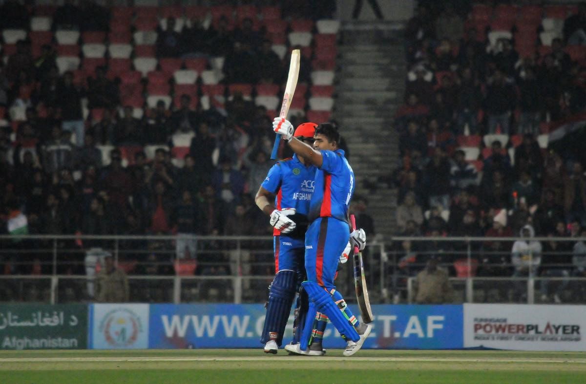 Afghanistan batsman Hazratullah Zazai (right) celebrates after reaching his century against Ireland in the second T20I in Dehradun on Saturday. AFP