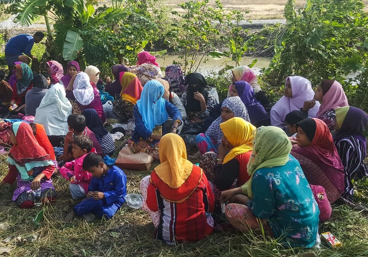 Rohingya refugees, who landed on an isolated northern shore near the Malaysia-Thai border, huddle in a group in Kangar on March 1, 2019, following their detention by Malaysian immigration authorities. - Thirty-four Rohingya landed on an isolated beach in