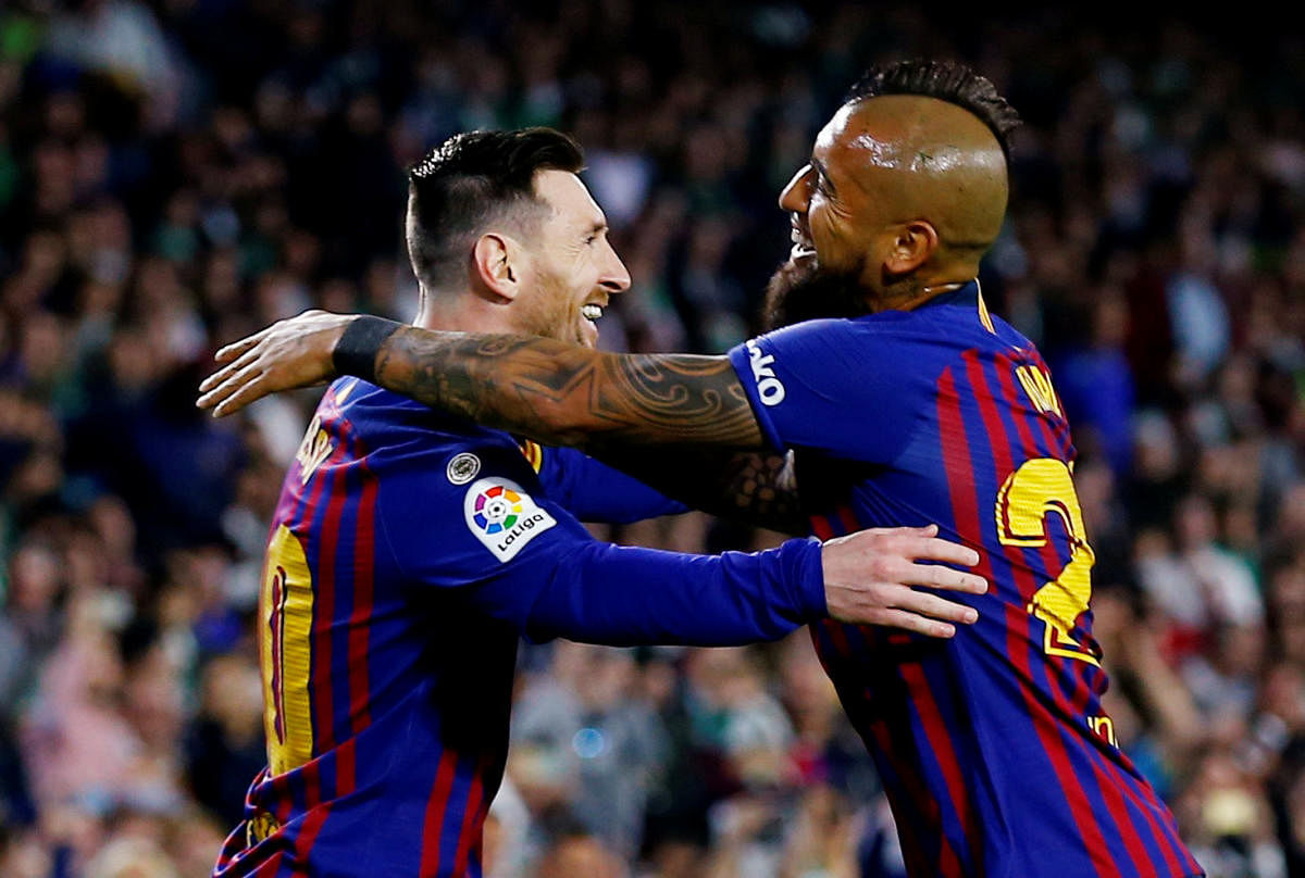 Barcelona's Lionel Messi celebrates with Arturo Vidal after scoring his first goal against Real Betis on Sunday. REUTERS
