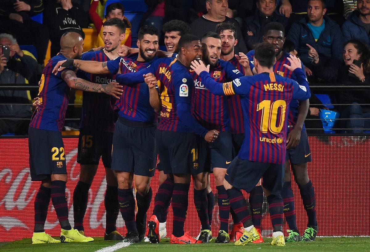 Barcelona players celebrate after Luis Suarez scored a 93rd-minute equaliser against Villarreal on Tuesday. AFP
