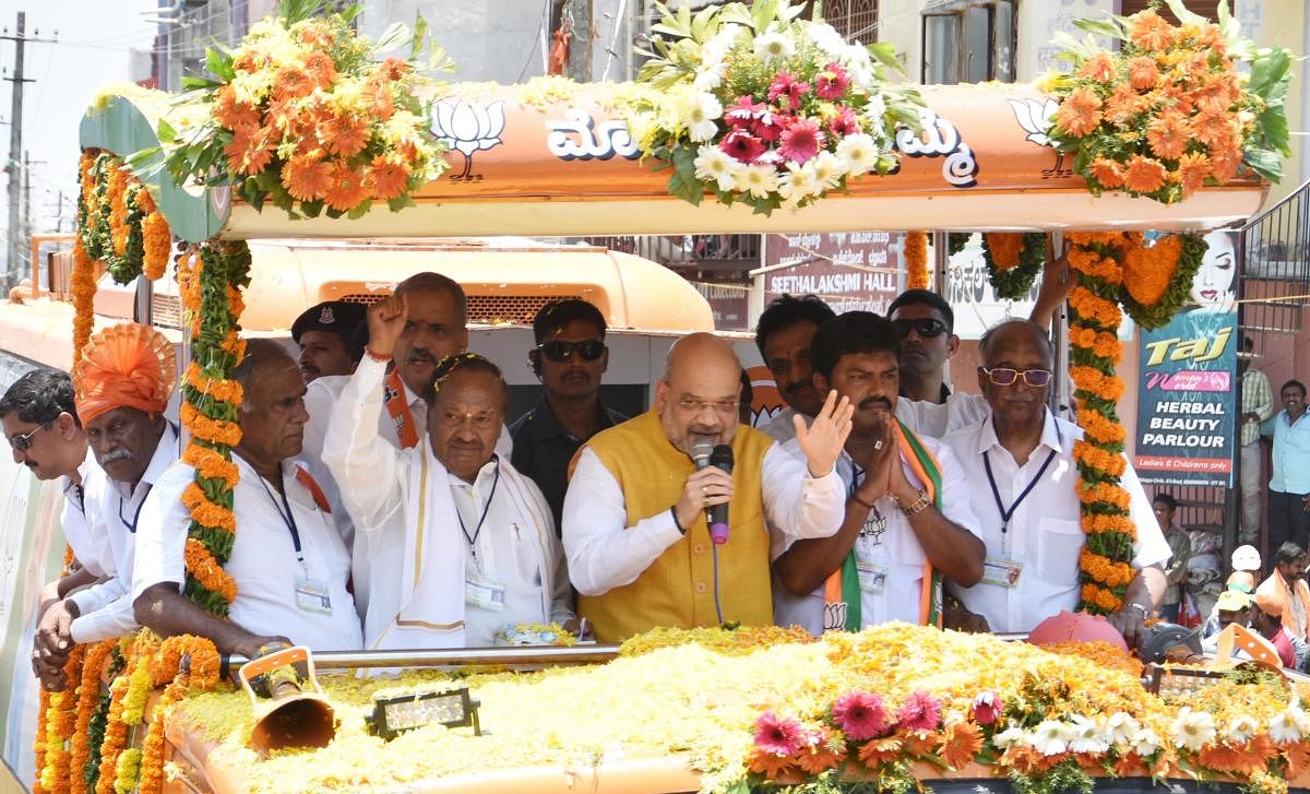 BJP National President Amit Shah speaks at road show organised by BJP to campaign in favour of the party nominee B Y Raghavendra in Bhadravathi town on Saturday.