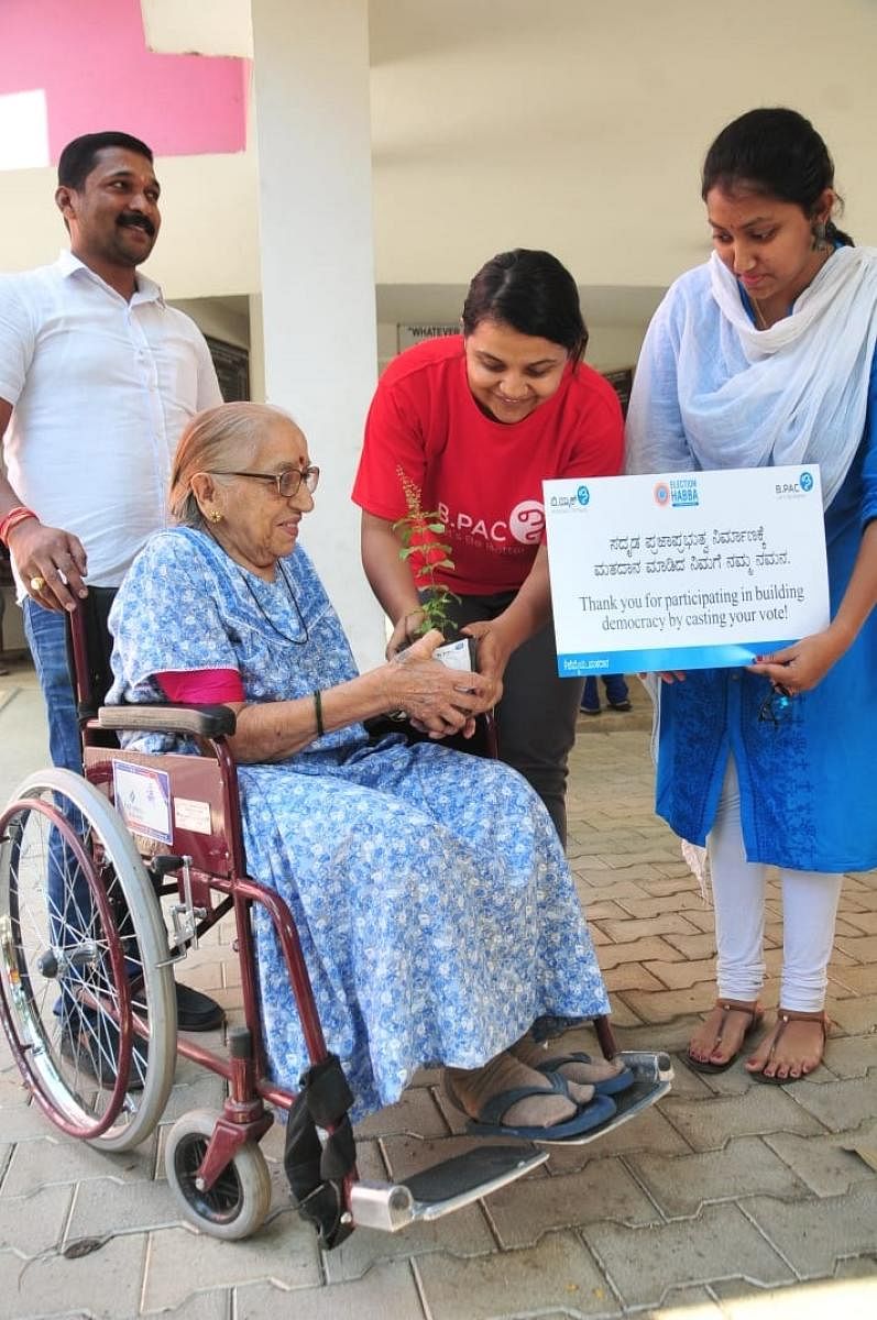 Archana M V from B.PAC gives away a tulsi sapling to a senior citizen who took the trouble to vote.