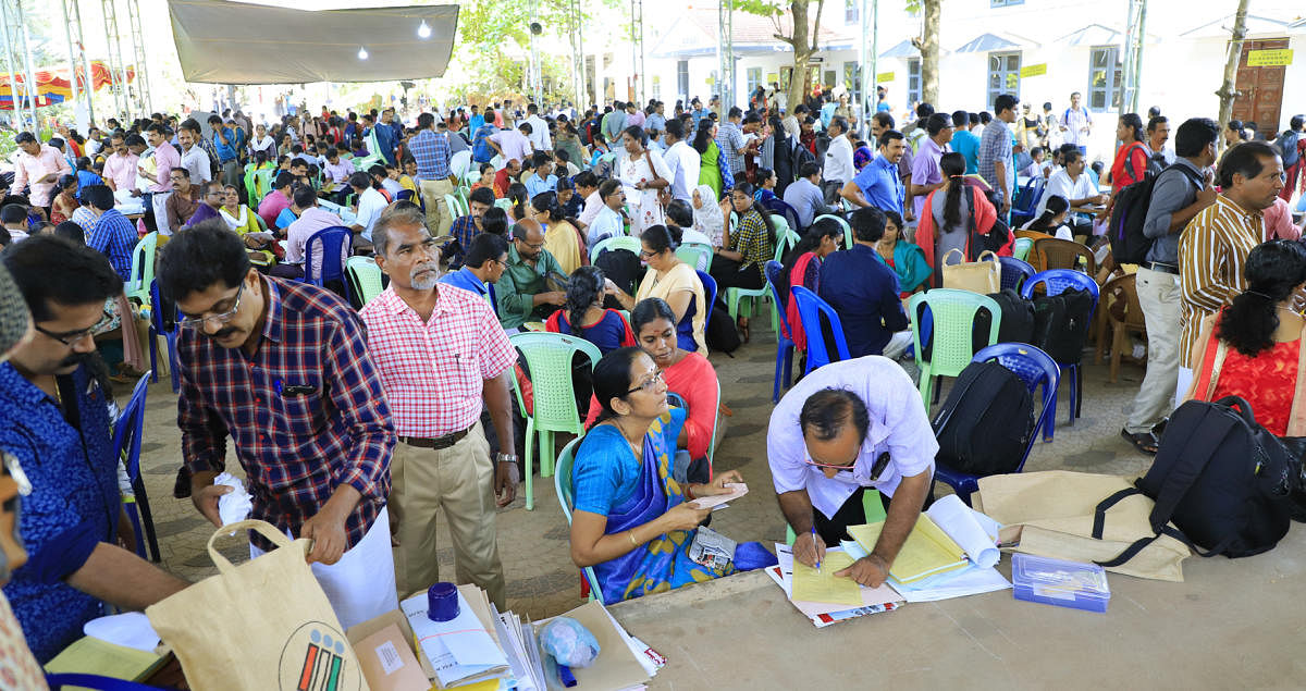 Officers collect election materials at a mustering centre in Kasargod on Monday.