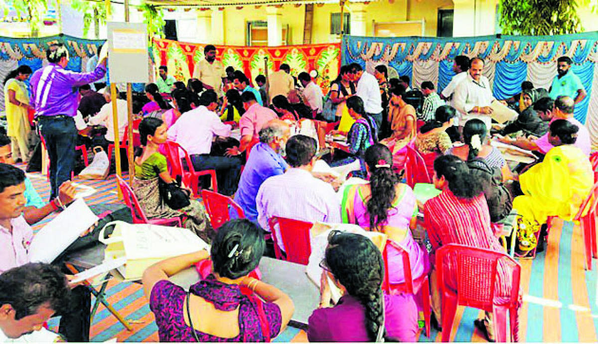 Polling officials verifying the documents pertaining to polling booth at mustering centre, Government PU College, Byndoor.