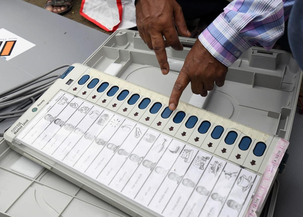 An Indian election official examines an Electronic Voting Machine (EVM) at a distribution centre ahead of the third phase of India's general election at Amigaon in Kamrup district in the northeastern state of Assam on April 22, 2019. (Photo by Biju BORO / AFP)