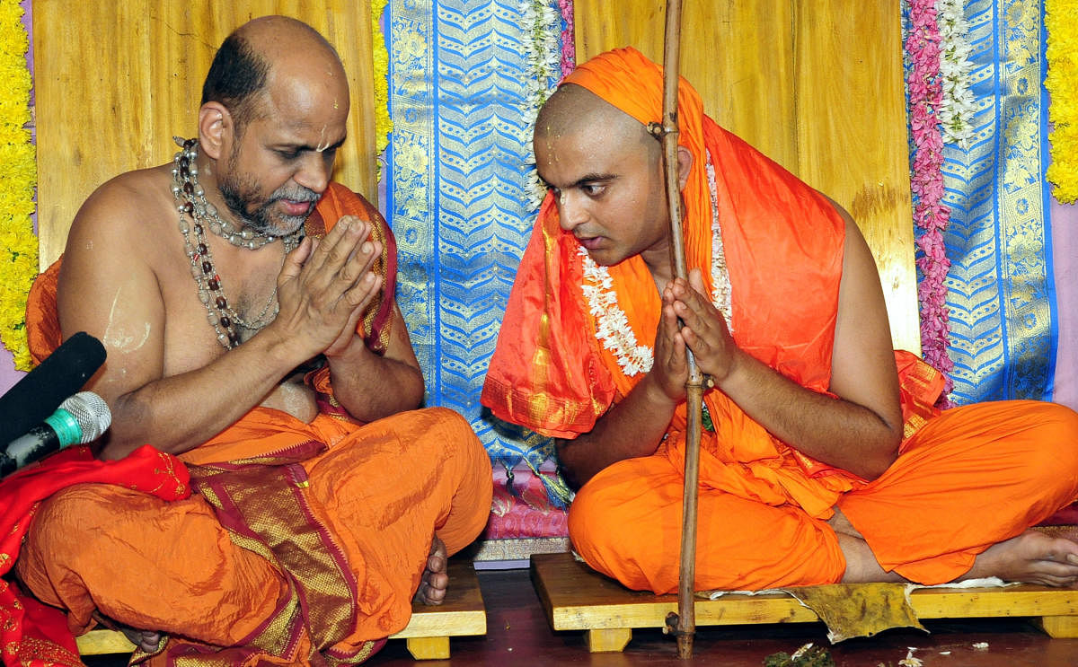 Puttige Mutt seer Sugunendratheertha Swami with his successor Sushreendratheertha Swami during the anointment ceremony at Hiriyadka in Udupi district on Monday. dh photo