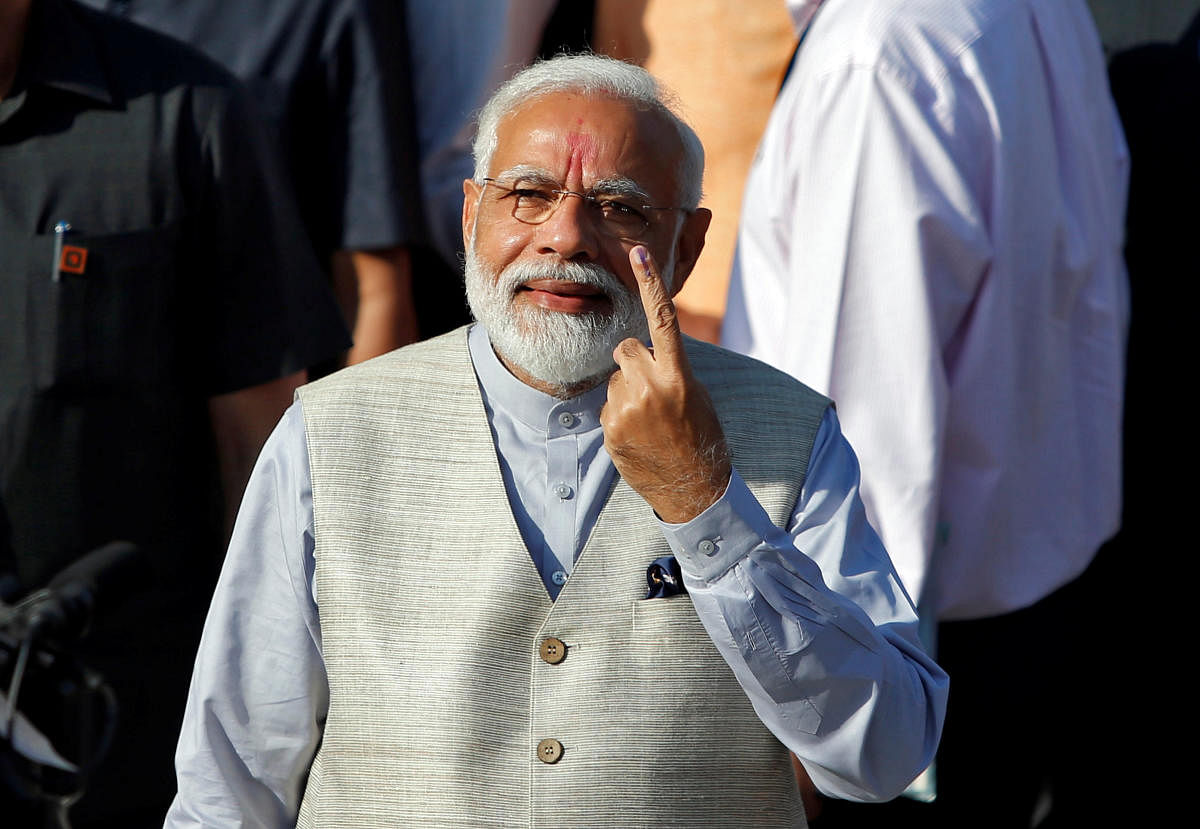 Prime Minister Narendra Modi shows his ink-marked finger after casting his vote outside a polling station during the third phase of general election in Ahmedabad, India, April 23, 2019. (REUTERS)