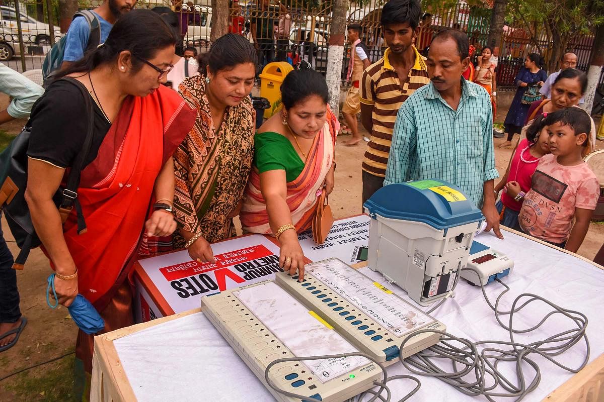 Poll officials aware people EVM (Electronic Voting Machine) and Voter Verified Paper Audit Trial (VVPAT) machine at a camp in Guwahati on April 13, 2019. (PTI Photo) 