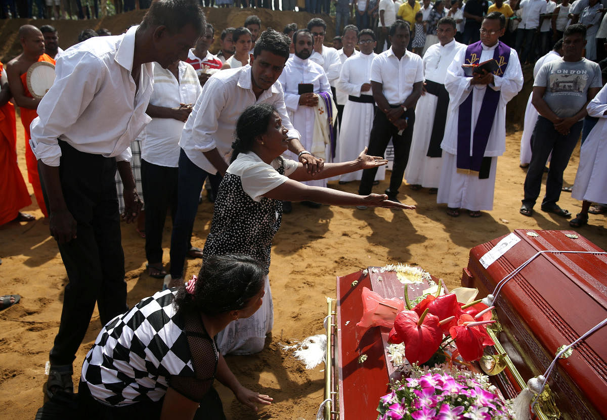 Women react during a mass burial of victims, two days after a string of suicide bomb attacks on churches and luxury hotels across the island on Easter Sunday, at a cemetery near St. Sebastian Church in Negombo, Sri Lanka April 23, 2019. REUTERS/Athit Pera